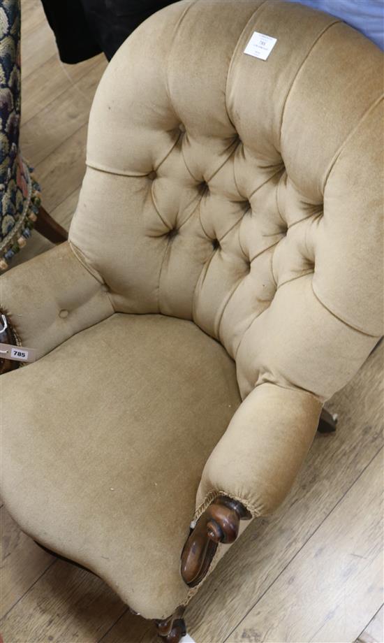 A Victorian mahogany-framed low armchair with scrolled terminals, deep-buttoned beige upholstery